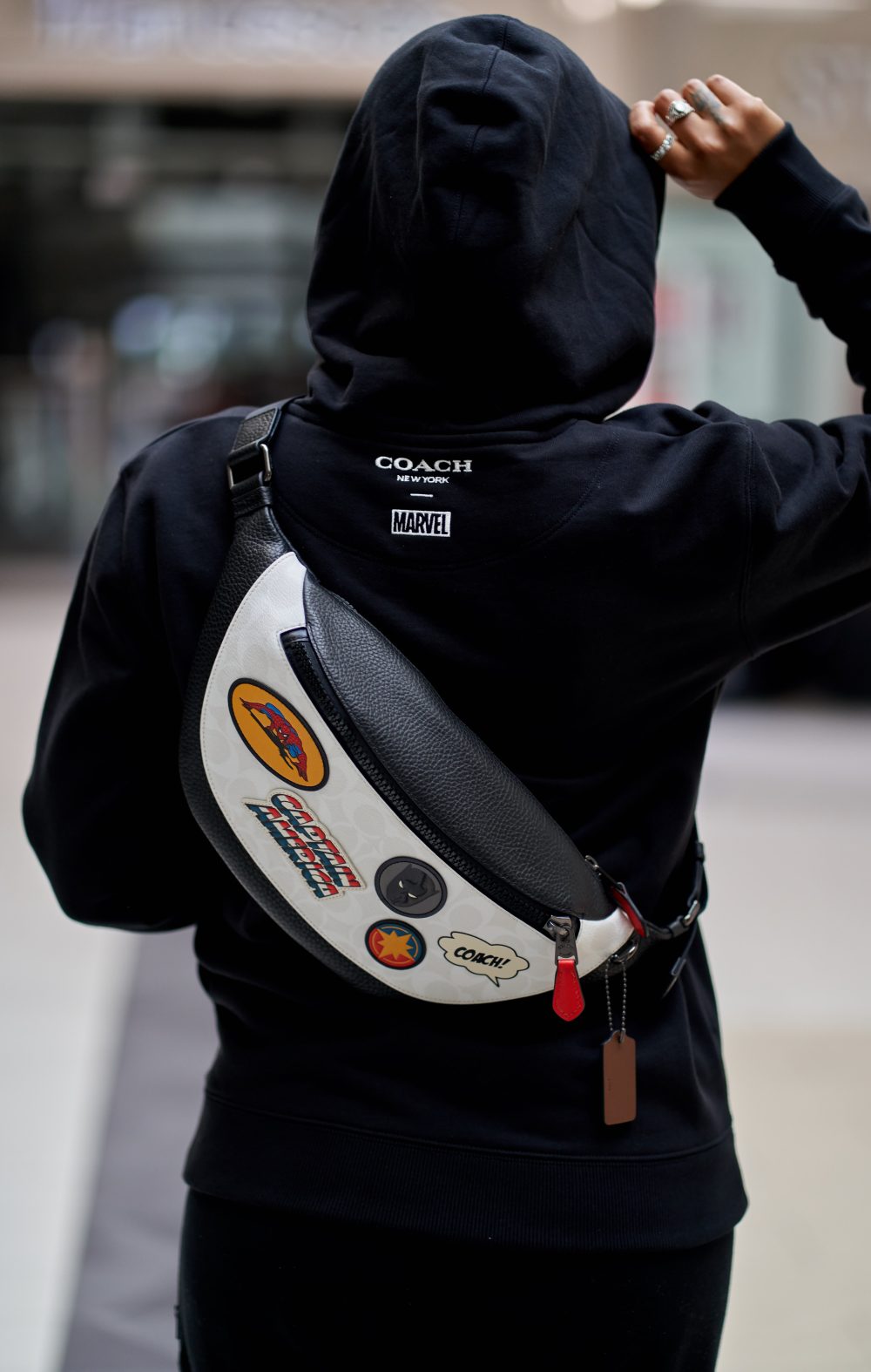 Lifestyle campaign shoot featuring a model walking away from the camera with a luxury fanny pack across her back, showcasing its practical and stylish design.”